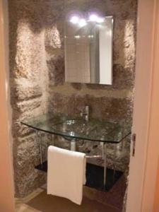 特拉什杜博魯的住宿－Casa de Campo Monte Abades，一间带玻璃水槽和镜子的浴室