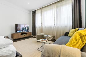 a living room with a couch and a tv at LUXOMES - Spacious Studio for 4 - Kitchen - Parking in Ingolstadt