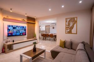 un soggiorno con un divano e una TV di Roots Villa Sequoia a Braşov