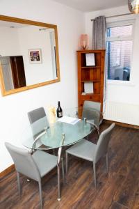 a dining room with a glass table and chairs at Cheerful 2 bedroom house in the heart of Belfast in Belfast