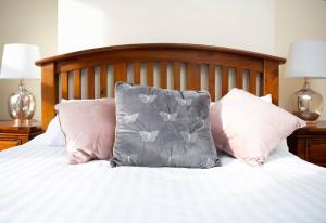 a bed with three pillows on it with two lamps at Cheerful 2 bedroom house in the heart of Belfast in Belfast
