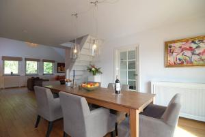 a dining room and living room with a table and chairs at Vakantiewoning Osebos in Gulpen