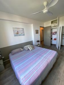 マシナッジオにあるSur le port de Macinaggio, au calmeのベッドルーム1室(大型ベッド1台、ストライプ毛布付)