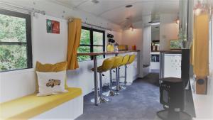 eine Bar in einem Zugwagen mit gelben Stühlen in der Unterkunft Willow Valley Glamping in Bude