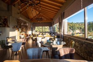 a restaurant with tables and chairs and a large window at Mylaon Boutique Hotel & Spa in Vytina