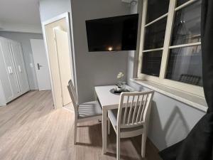 a dining room with a table and chairs and a television at Hotel am Rathaus Adii in Tangermünde