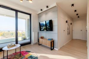 a living room with a large window and a tv at Apartament Baltica Portova Gdynia in Gdynia