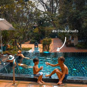 四色菊的住宿－Vijit Nakorn Hotel，一群儿童坐在游泳池里