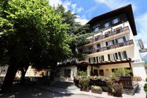 un edificio con dei fiori davanti di Hotel Pinzolo-Dolomiti a Pinzolo