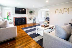 a living room with two couches and a fireplace at Cape Harbor Cottage in West Yarmouth