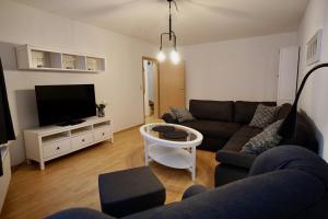 sala de estar con sofá y TV de pantalla plana en Ferienwohnung Badstaven en Wismar