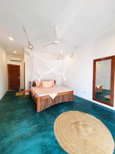 een slaapkamer met een bed, een spiegel en een tapijt bij Siri Beach Lodge in Nungwi