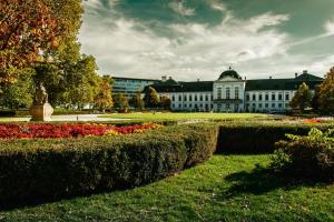 a large white building with a garden in front of it at Dagmar Apartment in Bratislava