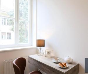 una mesa con un plato de pan y una lámpara en Dagmar Apartment, en Bratislava