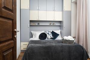 a bedroom with a bed with white cabinets and pillows at Villa Adelaida in Sarajevo