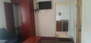a living room with a flat screen tv on a wall at The Crown Place in Kericho