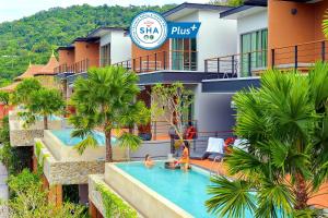 ein Hotel mit einem Schwimmbad vor einem Gebäude in der Unterkunft Le Resort and Villas in Rawai Beach