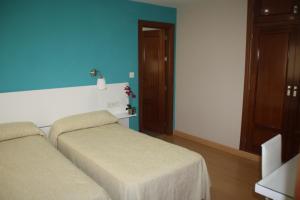 a bedroom with two beds and a blue wall at Verona in Granada