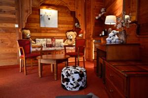 deux ours en peluche assis dans une pièce avec une table dans l'établissement Hôtel Serre Palas, à Les Deux Alpes