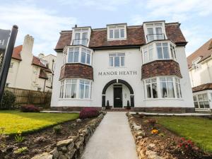 een wit gebouw met het gezondheidsbord van het landhuis erop bij Manor Heath Apartment 3 in Scarborough