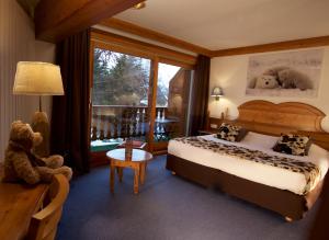 um quarto de hotel com uma cama e um ursinho de peluche em Hôtel Serre Palas em Les Deux Alpes
