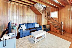 ein Wohnzimmer mit einem blauen Sofa und einer Treppe in der Unterkunft Green Gables Cottage in Friendship