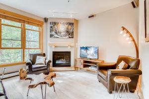 a living room with two chairs and a fireplace at Trappers Crossing Condo Unit 8769 in Keystone