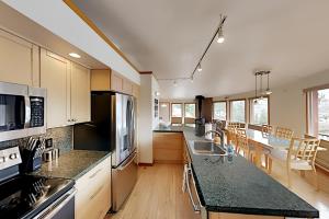 a kitchen with black countertops and a kitchen with a table at Retro Chic Roundhouse Retreat in Breckenridge