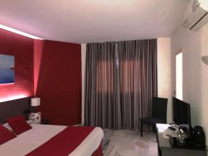 a bedroom with a large bed and a large window at Hotel Nerja Club Spa by Dorobe in Nerja