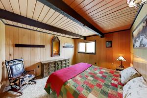 1 dormitorio con cama y techo de madera en Quaint Cabin, en Breckenridge