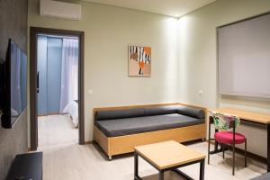 a room with a bed and a table and a tv at City Twins in Thessaloniki