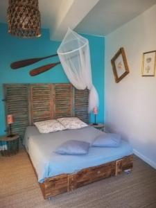 a bedroom with a bed with a net on the wall at Mas d'Antan in Saint-Paul-les-Fonts
