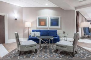 a living room with a blue couch and a table at Wyndham Philadelphia-Historic District in Philadelphia