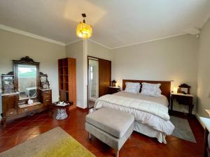 a bedroom with a bed and a chair and a window at Carpe Diem Azores in Mosteiros