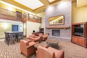 a lobby with a living room with a fireplace at AmericInn by Wyndham Ottumwa in Ottumwa