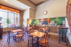 a restaurant with tables and chairs and a kitchen at AmericInn by Wyndham Ottumwa in Ottumwa