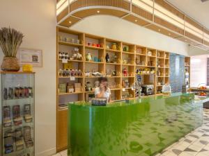 a woman standing behind a green counter in a store at greet Marseille Centre Saint Charles in Marseille