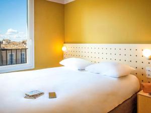 a bedroom with a large white bed with a window at greet Marseille Centre Saint Charles in Marseille