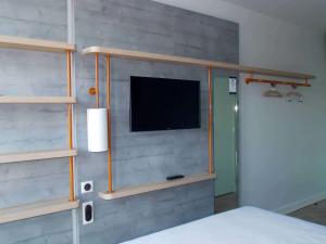 a bedroom with a bed with a tv on a wall at ibis budget Rouen Centre Rive Gauche in Rouen