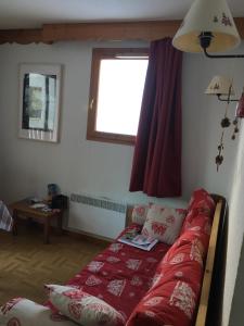 a living room with a red couch and a window at Puy St Vincent 1800 - appt 6 pers - près des pistes in Puy-Saint-Vincent