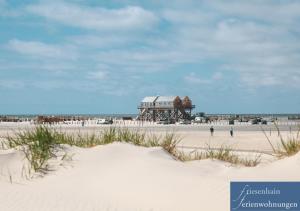 a beach with a house on the beach at Friesenhain Ferienwohnungen in Sankt Peter-Ording