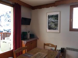 a dining room with a table and a window at Puy St Vincent 1800 - appt 6 pers - près des pistes in Puy-Saint-Vincent