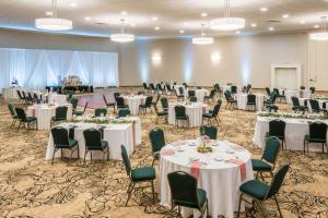 un salón de banquetes con mesas y sillas blancas en Penn Harris Hotel Harrisburg, Trademark by Wyndham, en Harrisburg