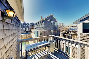 uma varanda com um banco numa casa em Long Pier Lodge em Provincetown