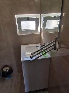 y baño con lavabo blanco y espejo. en Casa da Praia Alfarim, en Sesimbra