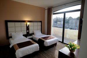 מיטה או מיטות בחדר ב-Ambassador City Hotel - Bethlehem