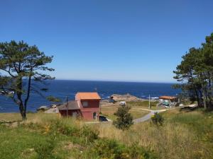 Apartamento Peregrinos Por la Costa Camino Portugués As Casetas في Rosal: منزل على تل بجوار المحيط