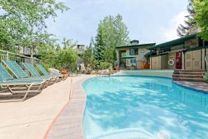 a swimming pool with chairs and a house at Tamarak 36 in Snowmass Village
