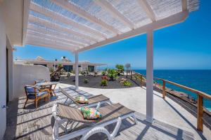 a patio with a table and chairs and the ocean at Etti - Paradise Suite El Olivo y el Mar in Pájara