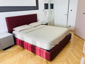 uma cama com uma moldura vermelha num quarto em BILOCALE_TORINO_DELUXE em Turim